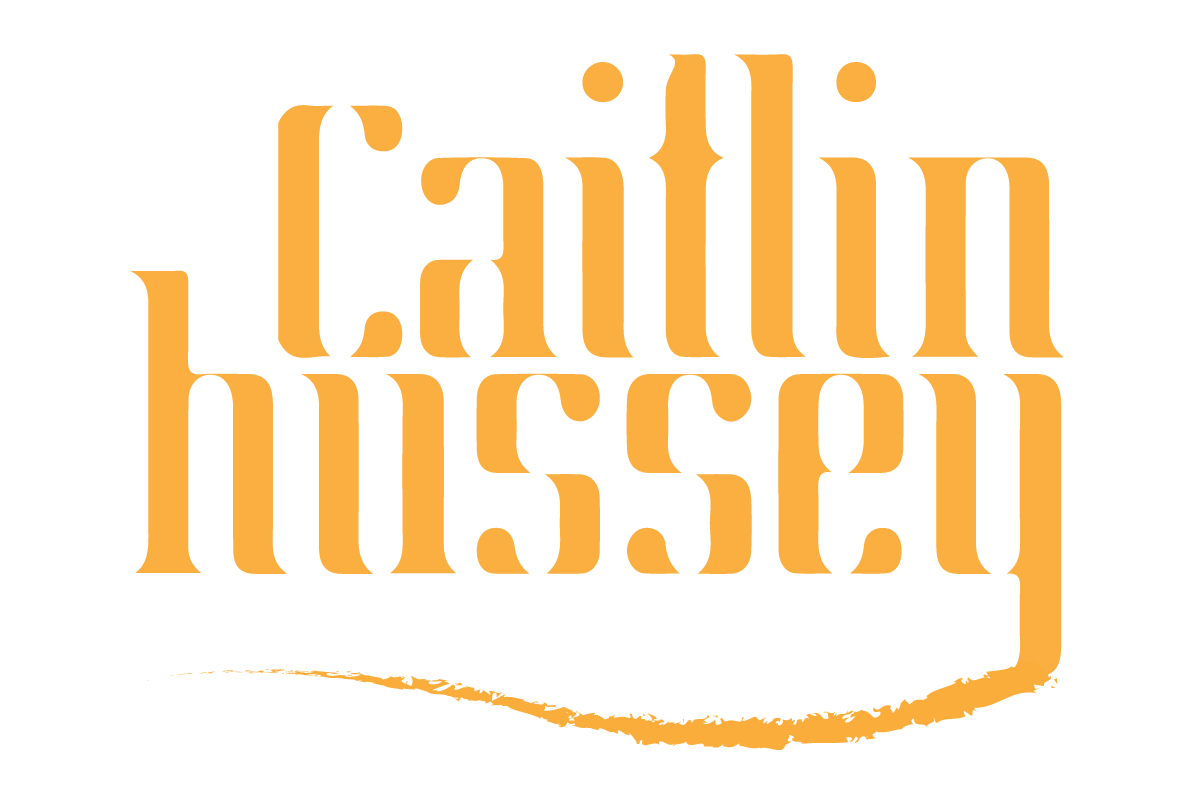Caitlin Hussey typographical-treatment logo. This logo features a black-letter typeface named Manufraktur. Black-letter typefaces are inspired by early printing presses. They are thick, chunky and gothic in appearance. This typographical-treatment logo is a pale orange against a dark background.
